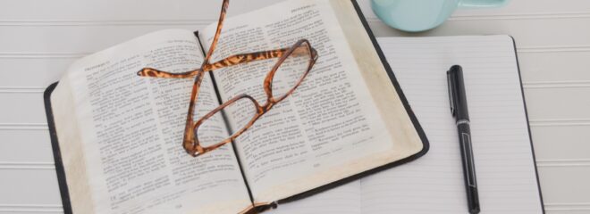 flat lay photography of tortoiseshell eyeglasses on top of book near black pen and teal mug